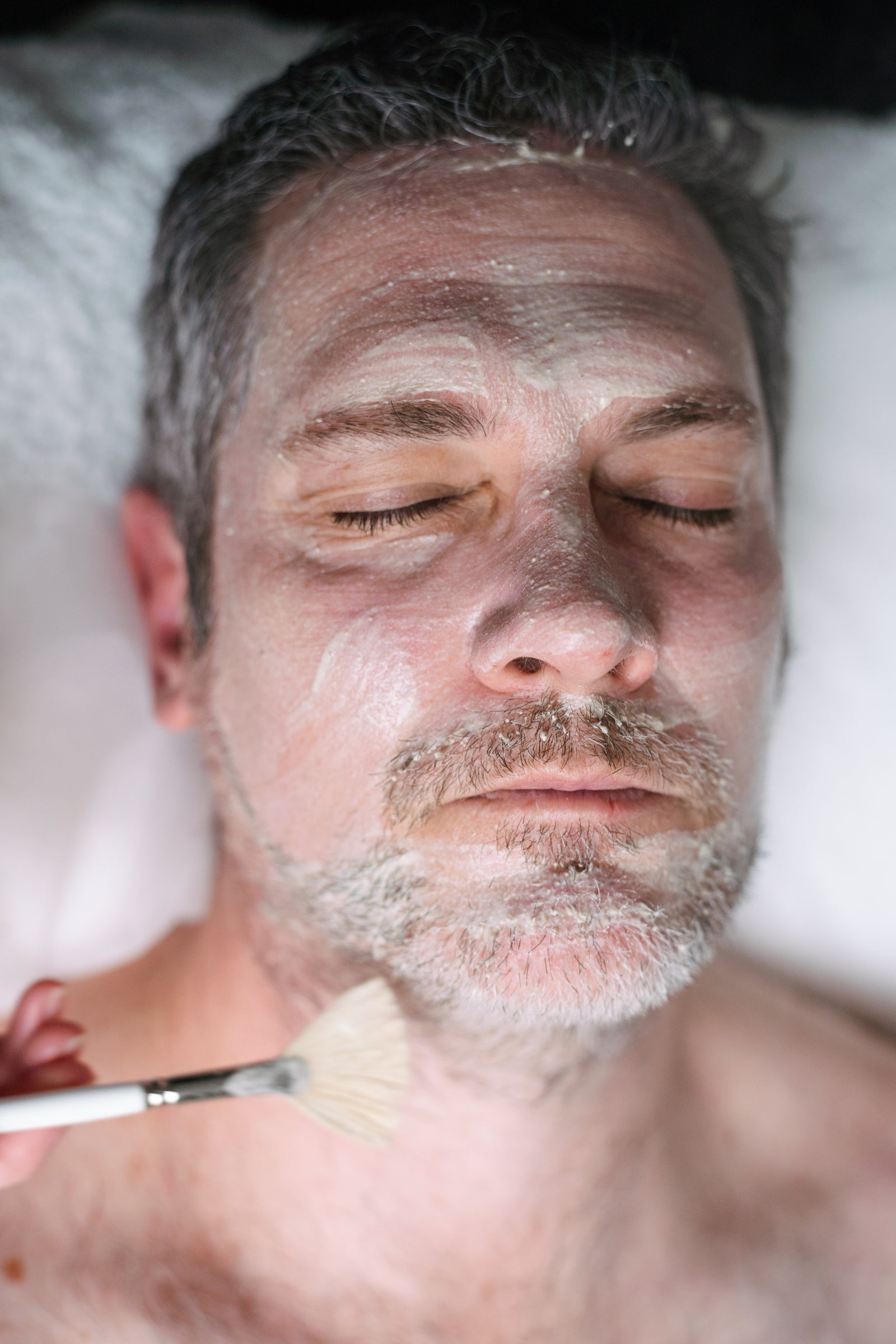 Male relaxing while having a men's facial at Sydney's Ilumaé Skin Bar